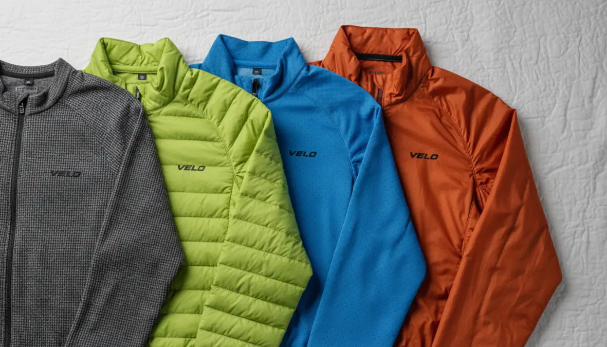 I tre strati di abbigliamento ciclismo primavera: strato base traspirante, maglia ciclismo e giacca isolante con protezione dal vento