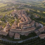 Destinazioni Italia non touristiche: piccolo borgo italiano autentico immerso nella campagna, con case in pietra e tetti di terracotta, lontano dal turismo di massa