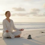 Donna che pratica meditazione consapevole sulla spiaggia durante una vacanza consapevole con mindfulness